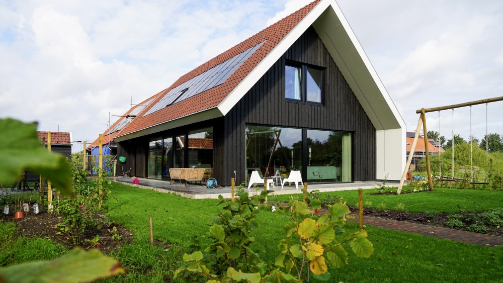 Gerealiseerd van schuurwoning met houten gevels, zadeldak en rode gegolfde dakpannen 1