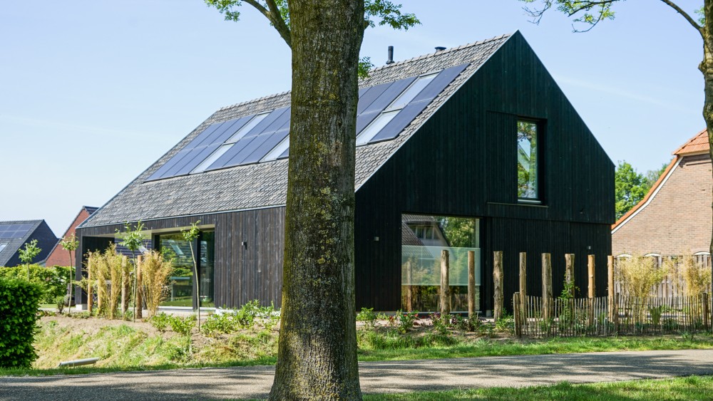 Gerealiseerd van landelijke schuurwoning met houten gevel, zadeldak en buiten shutters 1