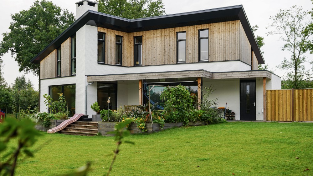 Gerealiseerd van duurzame woning met houten gevels, groendak en dakoverstek 3