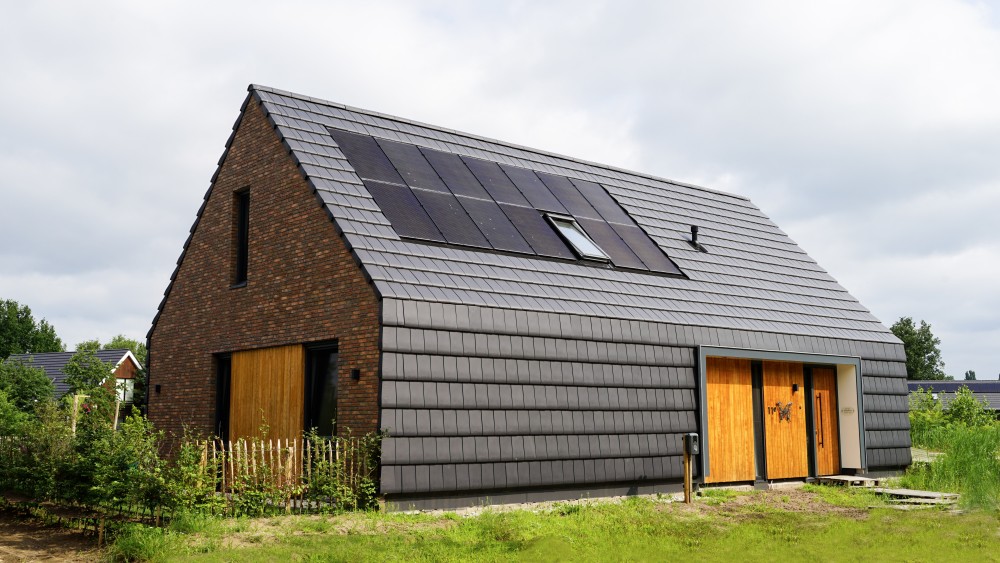 Gerealiseerd van schuurwoning met zadeldak, donkere gevelsteen en houten accenten 1
