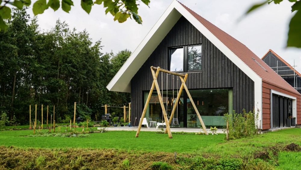 Gerealiseerd van schuurwoning met houten gevels, zadeldak en rode gegolfde dakpannen 2