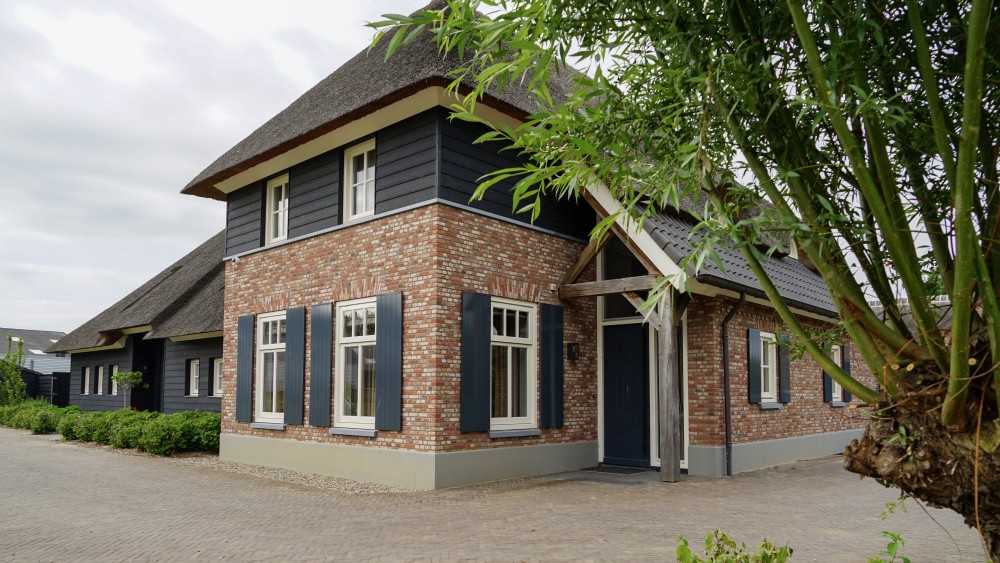 Gerealiseerd van landelijke tweekapper met rieten schilddak en houten geveldelen 1