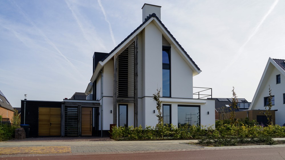 Gerealiseerd van moderne woning met strak pleisterwerk, houten accenten en royale overstekken 1
