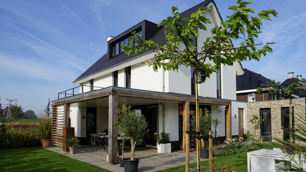 Gerealiseerd van moderne woning met strak pleisterwerk, houten accenten en royale overstekken 2