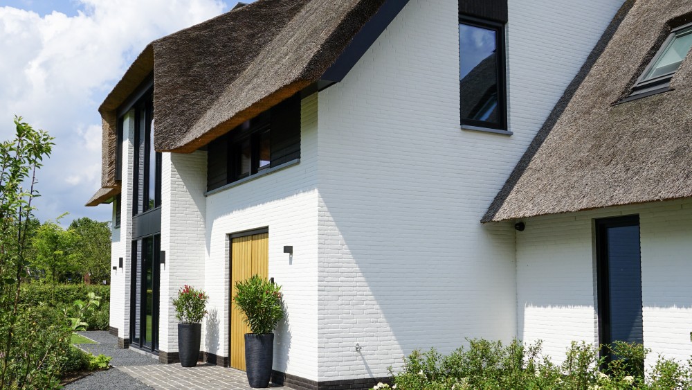 Gerealiseerd van rietgedekte villa met u-vorm, gekeimd metselwerk en risaliet 2